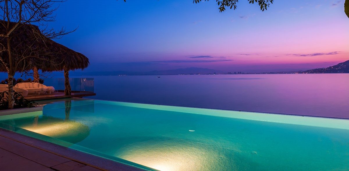 Sunset over an infinity pool and Banderas Bay in Puerto Vallarta